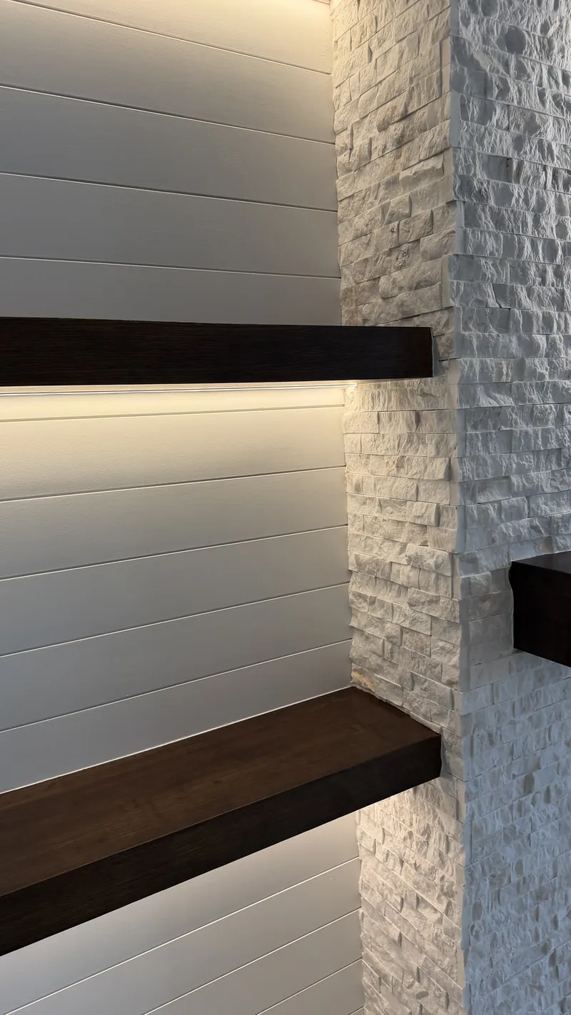 A lit shelf, white shiplap and the stone corner