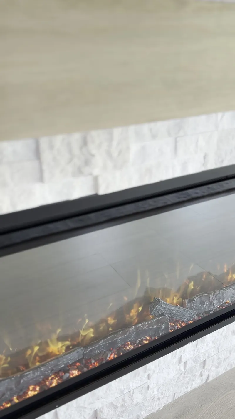 Flame and embers in the linear fireplace set into the stone