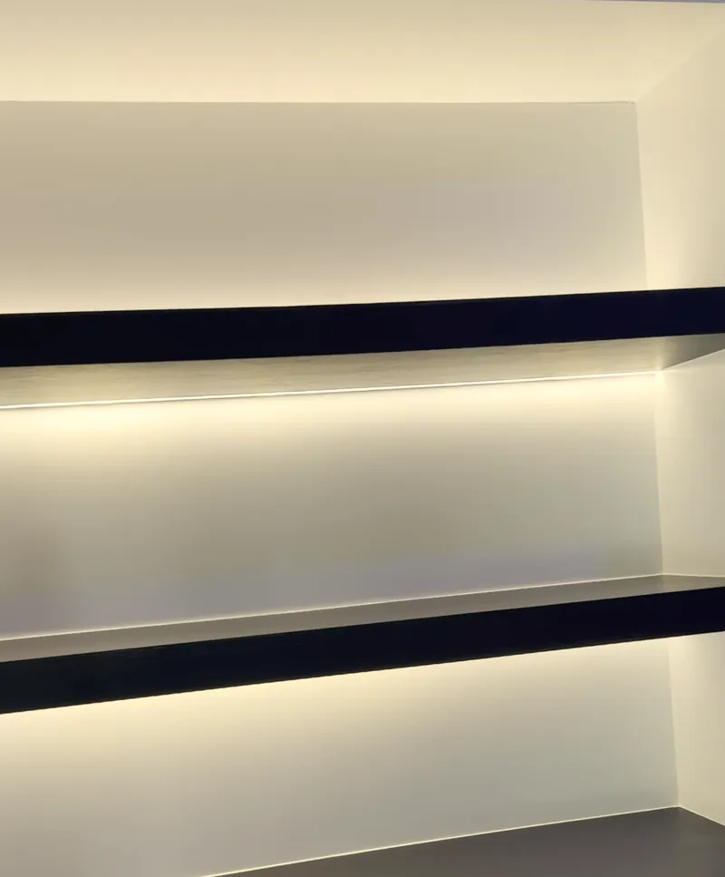 Dark floating shelves glowing warm white from the LED set under each shelf