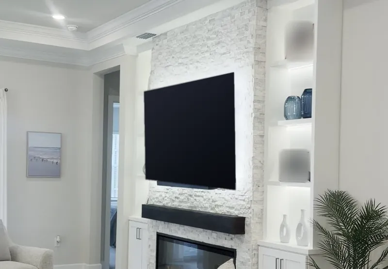 The living room with the stone fireplace wall and its lit towers at the far end