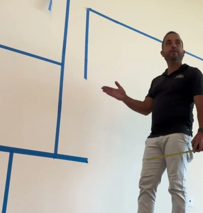 Jesse explaining a layout taped on an empty wall