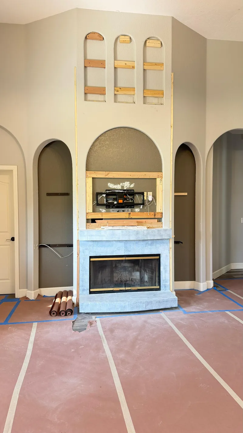During: floors covered, the TV frame going up and the shelf supports in the arches