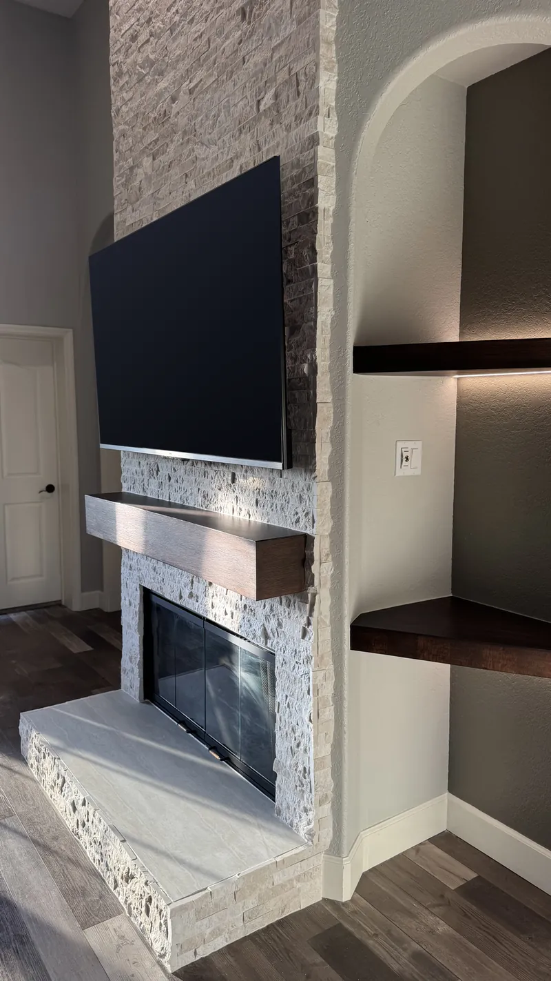 The mantel, the fireplace and a lit niche from the side