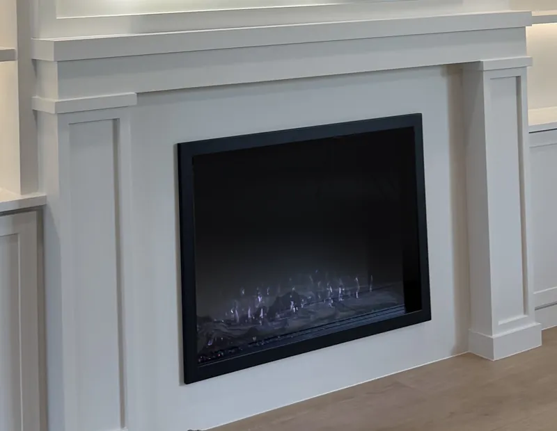 The fireplace set in the painted pilaster surround