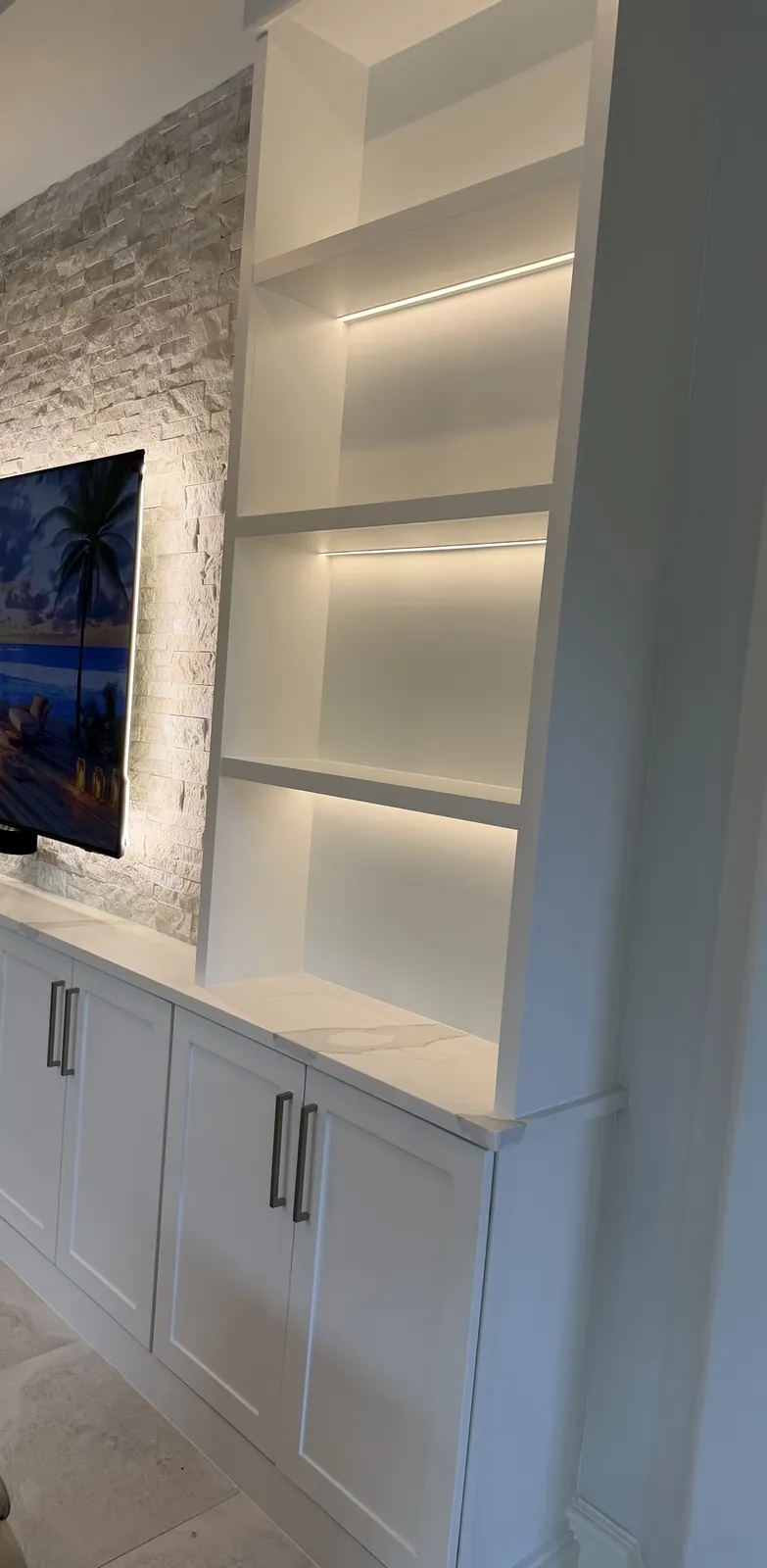 Shaker cabinets and a lit tower beside the stone
