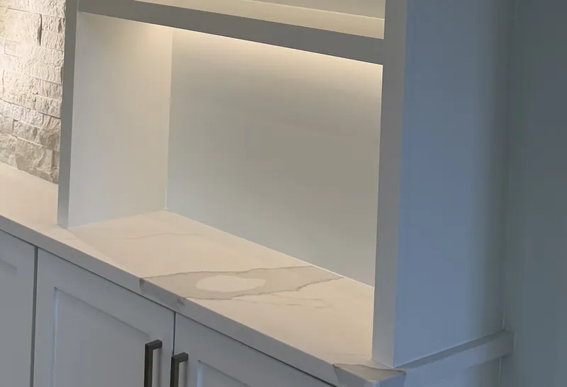 A white open tower over Shaker cabinets