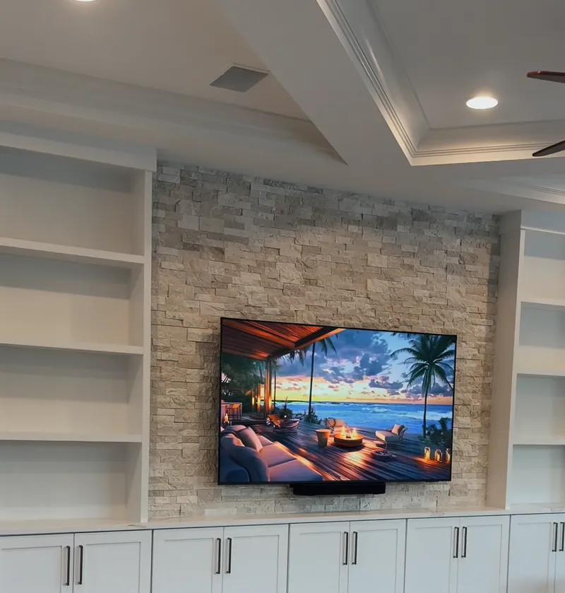 The wall with the shelf and stone lights off, only the TV on
