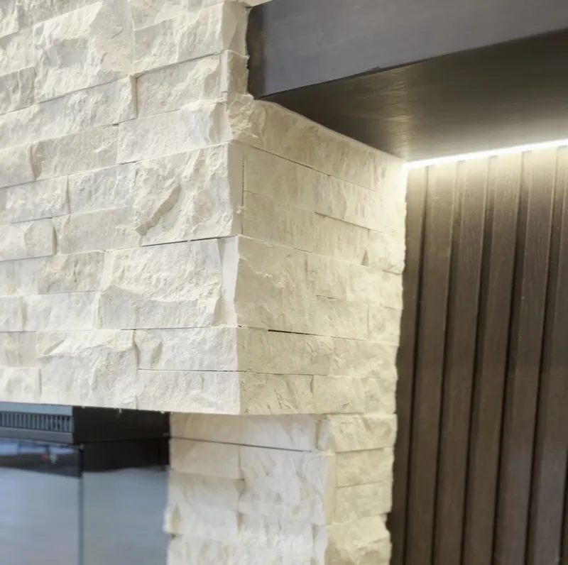 The stacked stone meeting the dark fluted panel