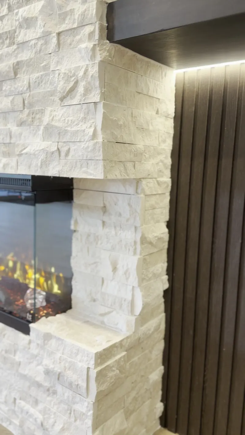 Stone corner beside the dark fluted panel