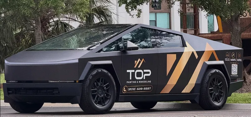 The black Top Painting and Remodeling Cybertruck with the gold logo on the side
